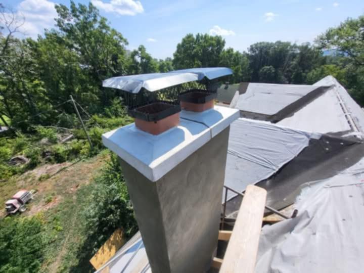 New chimney with fresh parge coat and dual flue caps by Rhinesmith Masonry