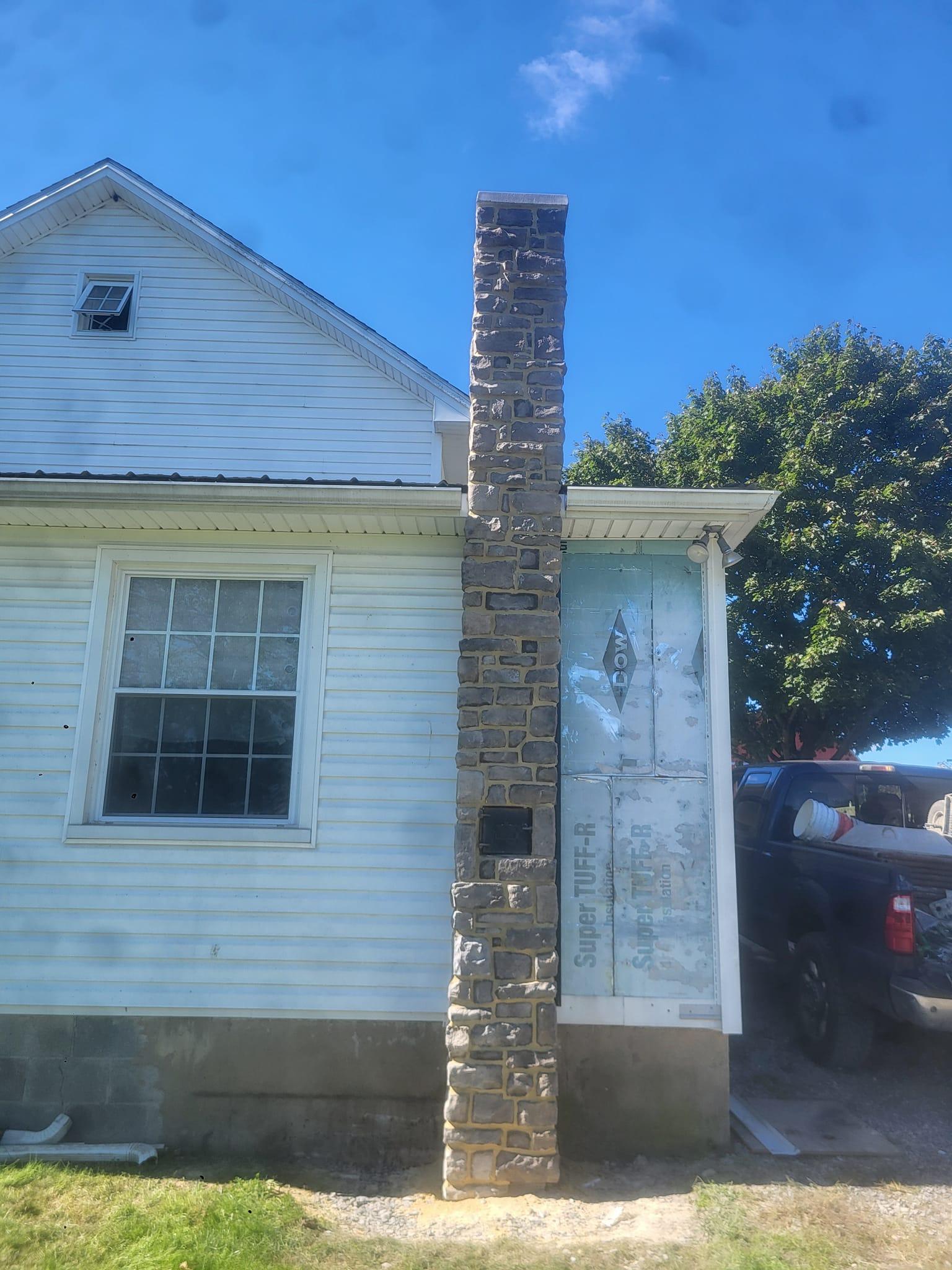 Stone chimney with custom cap and parge finish by Rhinesmith Masonry